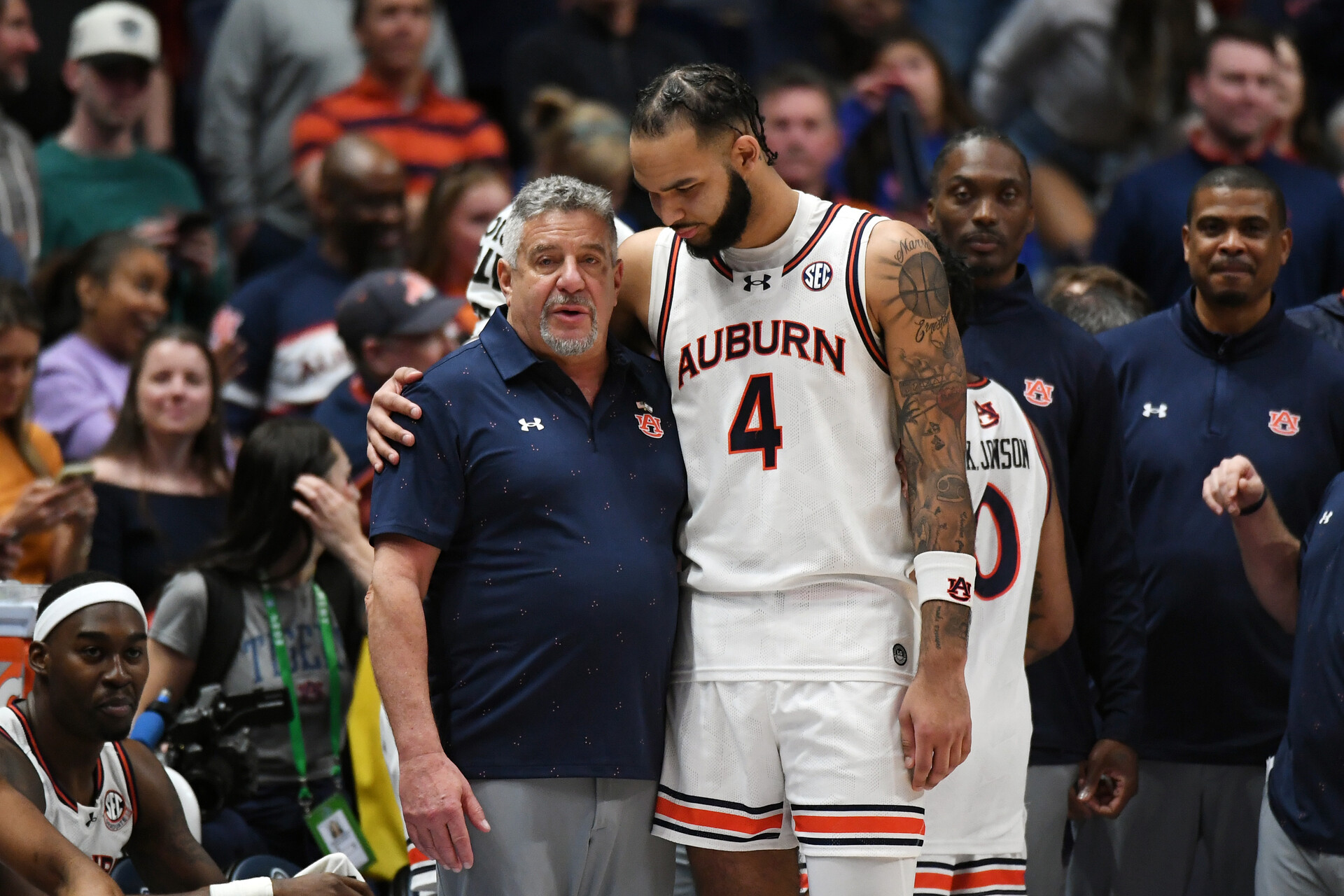 Mar 17, 2024; Nashville, TN, USA; Auburn Tigers forward Johni Broome (4) embraces head coach Bruce Pearl in the second half against the Florida Gators in the SEC Tournament championship game at Bridgestone Arena.