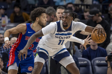 Mar 27, 2024; Minneapolis, Minnesota, USA; Minnesota Timberwolves center Naz Reid (11) backs towards the basket and keeps the ball away from Detroit Pistons guard Cade Cunningham (2) in the second half at Target Center.