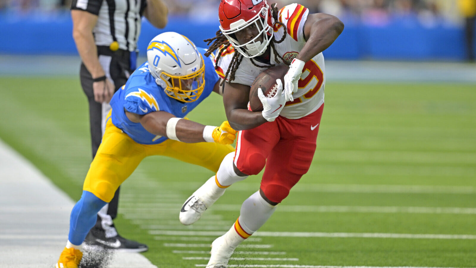 Sep 29, 2024; Inglewood, California, USA; Kansas City Chiefs running back Kareem Hunt (29) runs for a first down before he is forced out of bounds by Los Angeles Chargers linebacker Daiyan Henley (0) in the second half at SoFi Stadium.