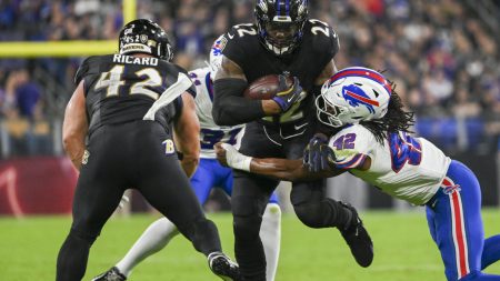 Sep 29, 2024; Baltimore, Maryland, USA; Baltimore Ravens running back Derrick Henry (22) runs through Buffalo Bills linebacker Dorian Williams (42) tackle attempt during the first half at M&T Bank Stadium.