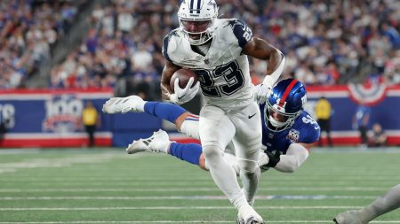 Sep 26, 2024; East Rutherford, New Jersey, USA; Dallas Cowboys running back Rico Dowdle (23) runs for a touchdown against New York Giants linebacker Micah McFadden (41) during the first quarter at MetLife Stadium.