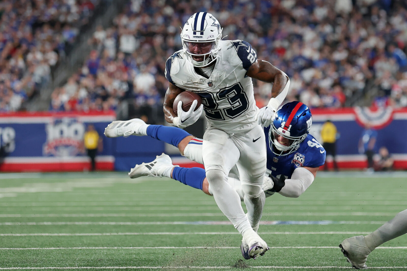 Sep 26, 2024; East Rutherford, New Jersey, USA; Dallas Cowboys running back Rico Dowdle (23) runs for a touchdown against New York Giants linebacker Micah McFadden (41) during the first quarter at MetLife Stadium.