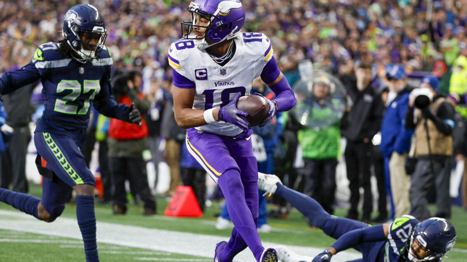 Dec 22, 2024; Seattle, Washington, USA; Minnesota Vikings wide receiver Justin Jefferson (18) catches a touchdown pass against Seattle Seahawks safety Julian Love (20) during the fourth quarter at Lumen Field.