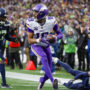 Dec 22, 2024; Seattle, Washington, USA; Minnesota Vikings wide receiver Justin Jefferson (18) catches a touchdown pass against Seattle Seahawks safety Julian Love (20) during the fourth quarter at Lumen Field.