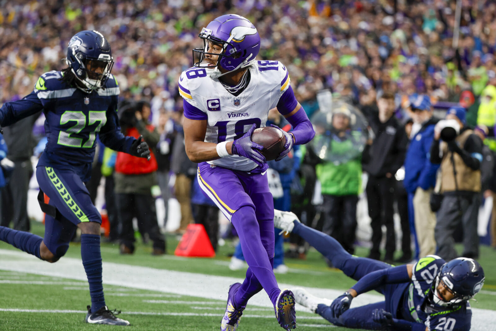 Dec 22, 2024; Seattle, Washington, USA; Minnesota Vikings wide receiver Justin Jefferson (18) catches a touchdown pass against Seattle Seahawks safety Julian Love (20) during the fourth quarter at Lumen Field.