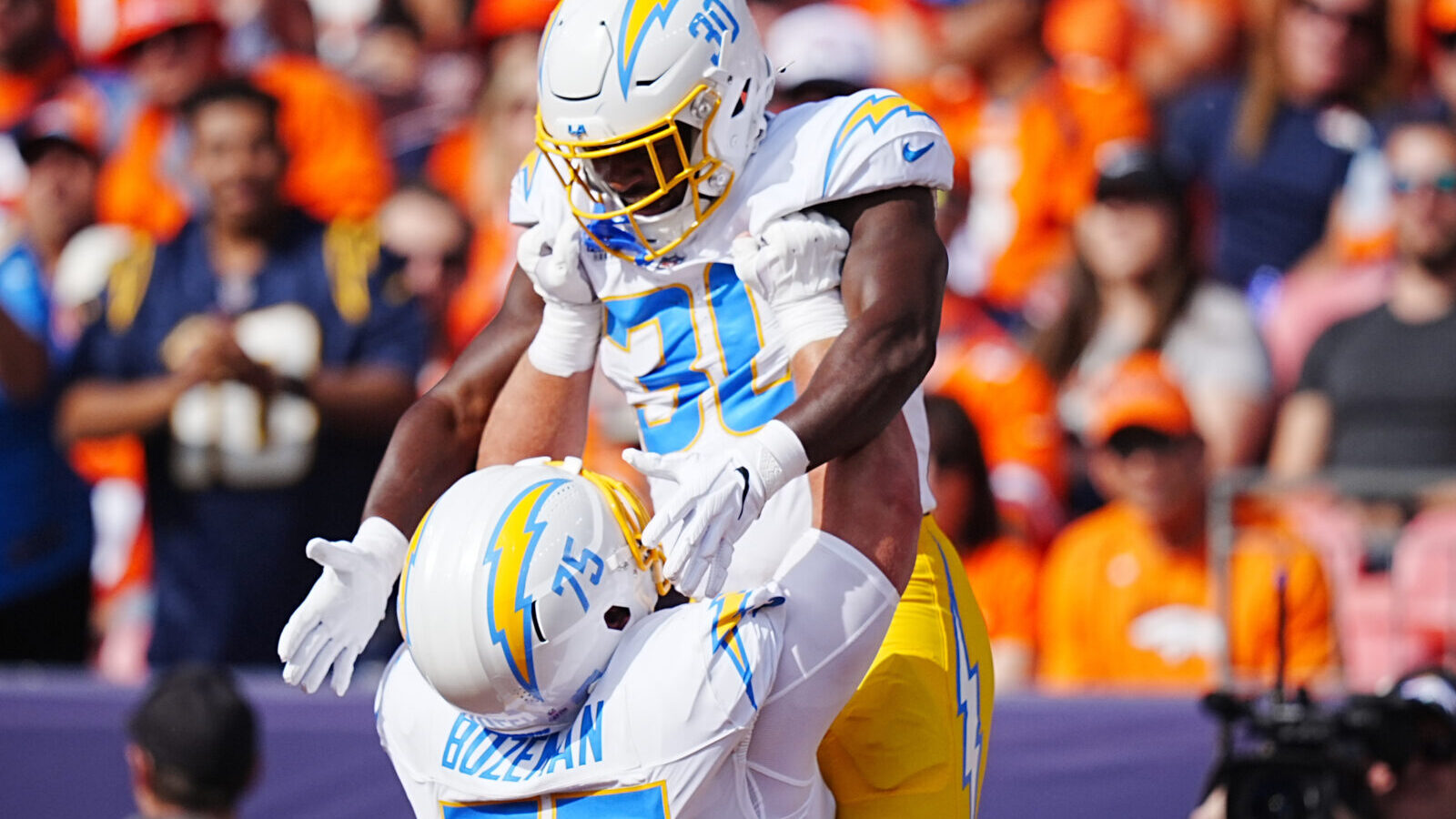 Oct 13, 2024; Denver, Colorado, USA; Los Angeles Chargers center Bradley Bozeman (75) celebrates running back Kimani Vidal (30) touchdown in the first quarter against the Denver Broncos at Empower Field at Mile High.