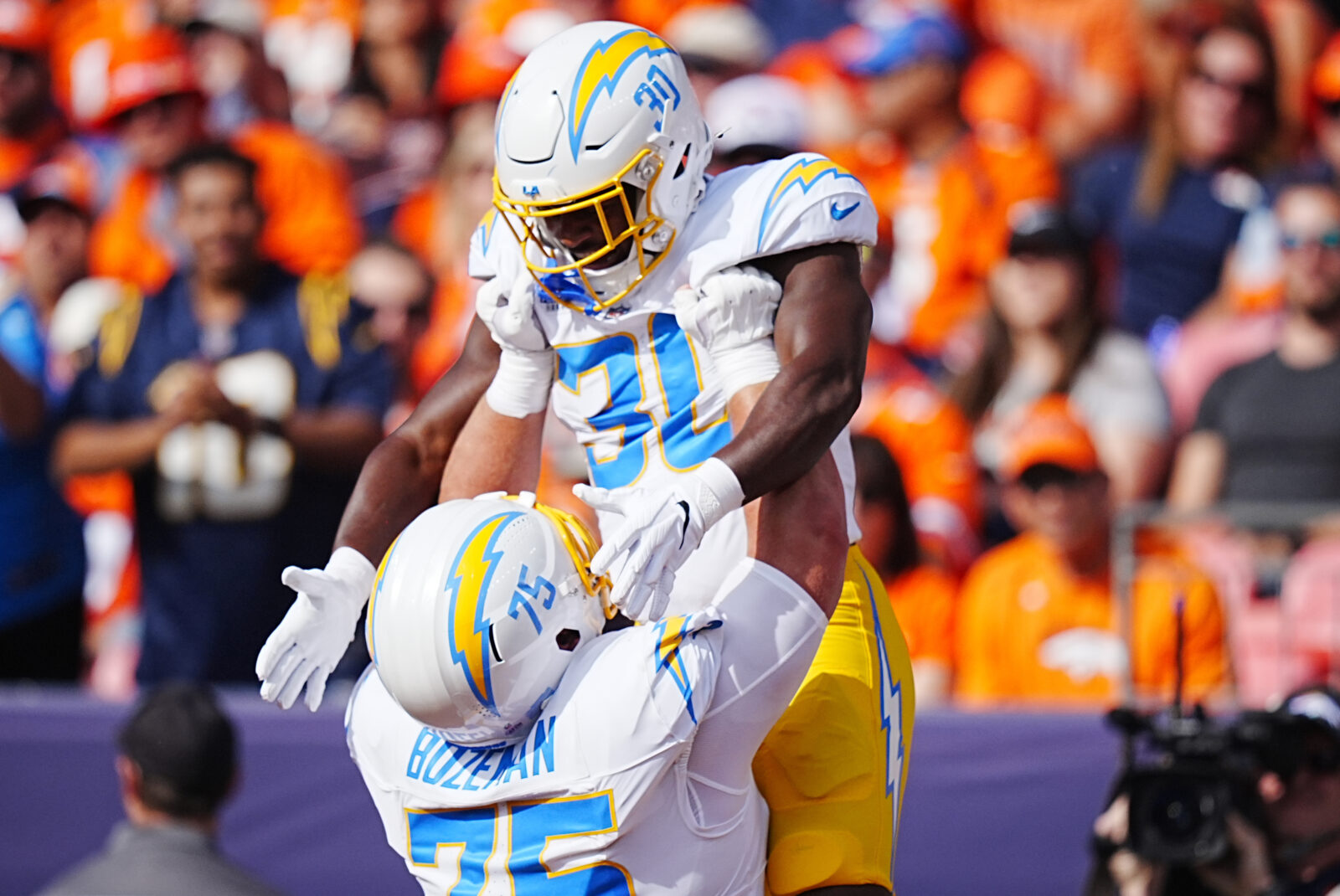 Oct 13, 2024; Denver, Colorado, USA; Los Angeles Chargers center Bradley Bozeman (75) celebrates running back Kimani Vidal (30) touchdown in the first quarter against the Denver Broncos at Empower Field at Mile High.