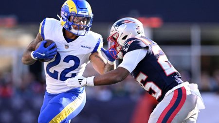 Nov 17, 2024; Foxborough, Massachusetts, USA; Los Angeles Rams running back Blake Corum (22) runs with the ball against New England Patriots cornerback Marcus Jones (25) during the first half at Gillette Stadium.