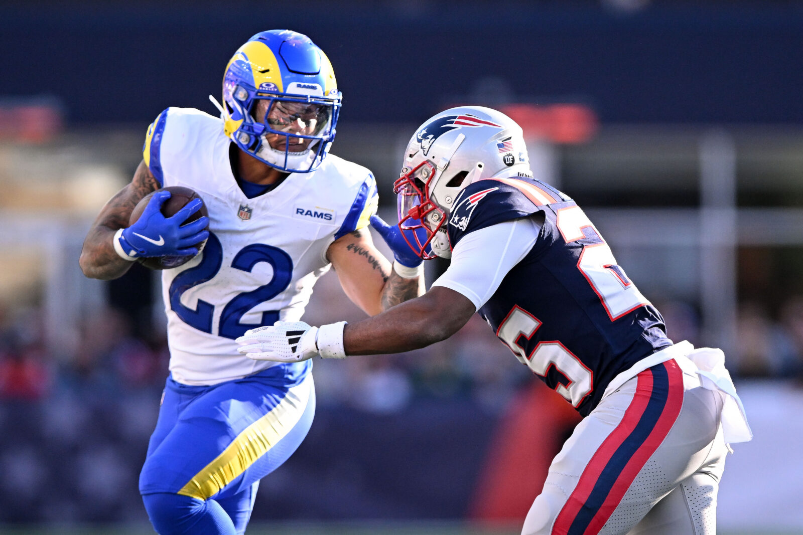 Nov 17, 2024; Foxborough, Massachusetts, USA; Los Angeles Rams running back Blake Corum (22) runs with the ball against New England Patriots cornerback Marcus Jones (25) during the first half at Gillette Stadium.