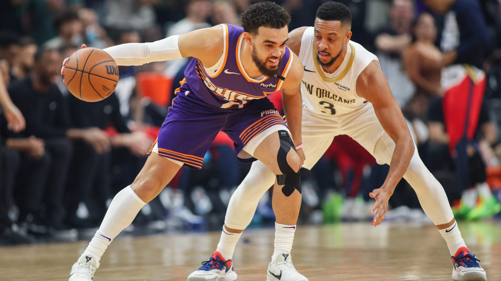 Feb 27, 2025; Phoenix, Arizona, USA; Phoenix Suns guard Tyus Jones (21) is defended by New Orleans Pelicans guard CJ McCollum (3) in the first quarter at Footprint Center.