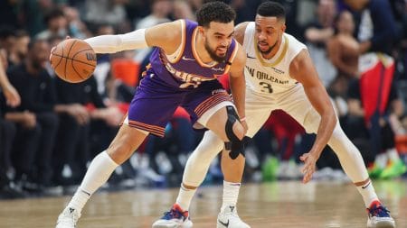 Feb 27, 2025; Phoenix, Arizona, USA; Phoenix Suns guard Tyus Jones (21) is defended by New Orleans Pelicans guard CJ McCollum (3) in the first quarter at Footprint Center.