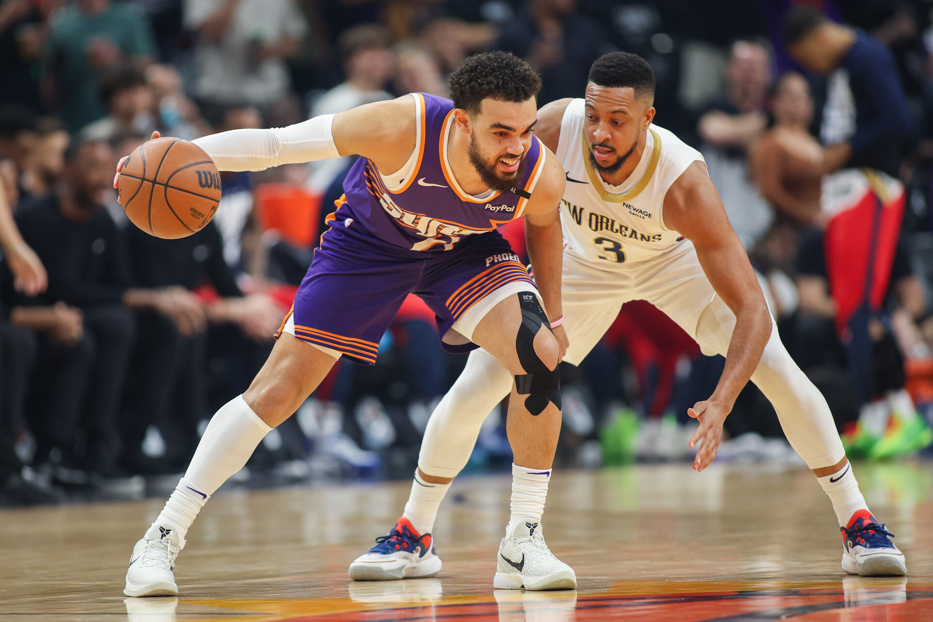 Feb 27, 2025; Phoenix, Arizona, USA; Phoenix Suns guard Tyus Jones (21) is defended by New Orleans Pelicans guard CJ McCollum (3) in the first quarter at Footprint Center.