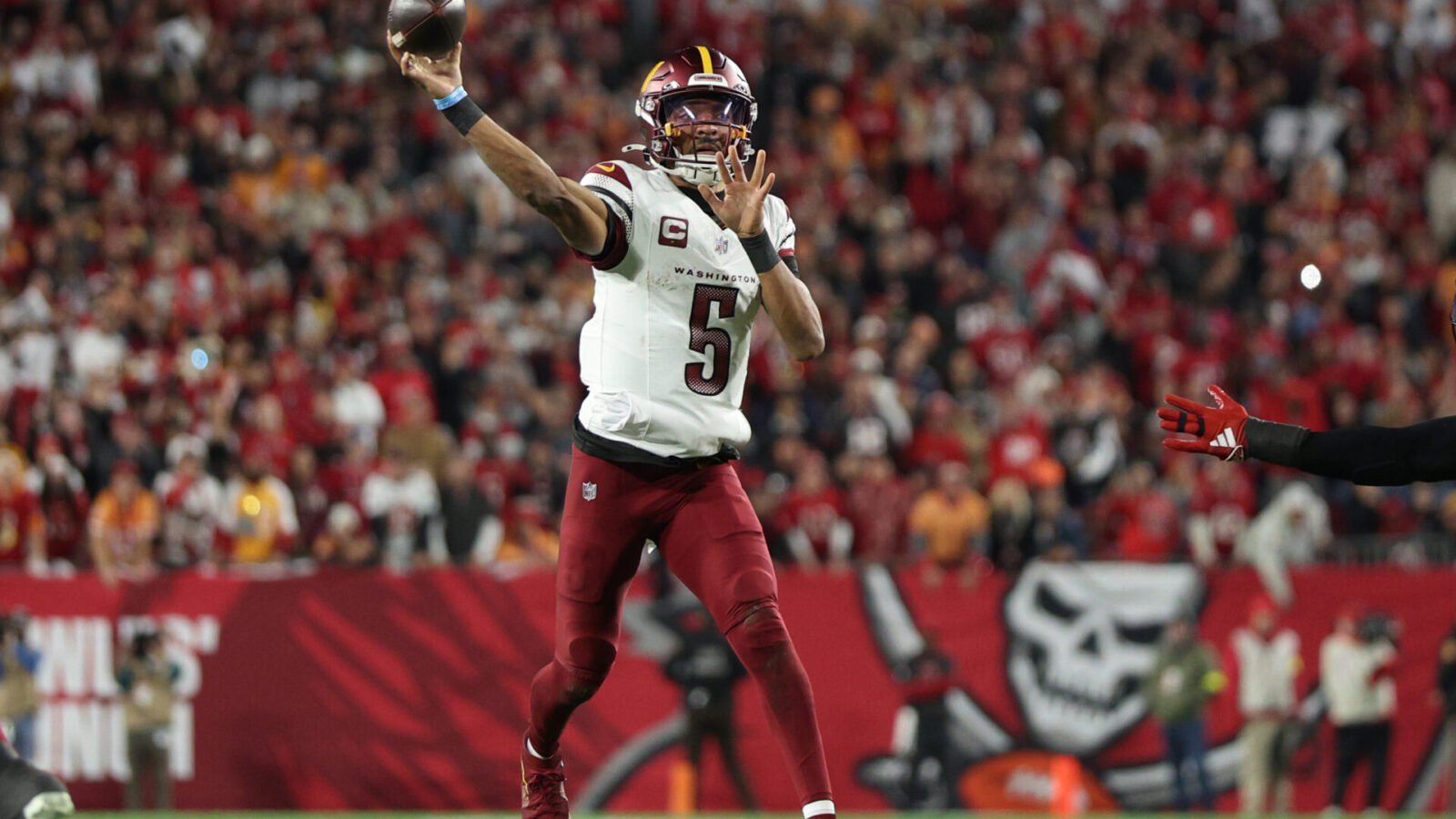 Jan 12, 2025; Tampa, Florida, USA; Washington Commanders quarterback Jayden Daniels (5) throws during the second quarter of a NFC wild card playoff against the Tampa Bay Buccaneers at Raymond James Stadium.