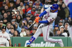 May 21, 2025; Boston, Massachusetts, USA; New York Mets right fielder Juan Soto (22) hits a RBI sacrifice fly during the seventh inning against the Boston Red Sox at Fenway Park.