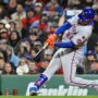 May 21, 2025; Boston, Massachusetts, USA; New York Mets right fielder Juan Soto (22) hits a RBI sacrifice fly during the seventh inning against the Boston Red Sox at Fenway Park.