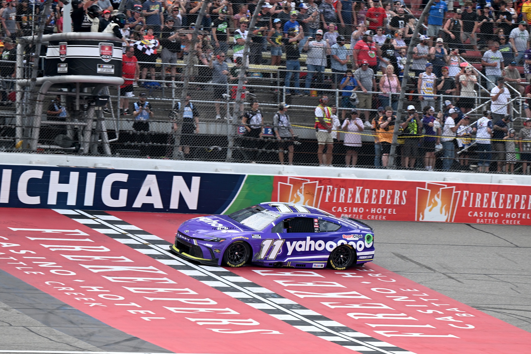 Jun 8, 2025; Brooklyn, Michigan, USA; NASCAR Cup Series driver Denny Hamlin (11) crosses the finish line to win the FireKeepers Casino 400 at Michigan International Speedway.