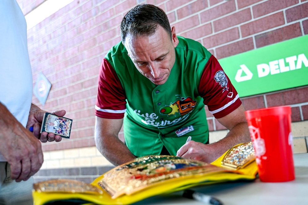 Nathan's Hot Dog Eating champion Joey Chestnut sings autographs before the Lugnuts game against the TinCaps on Thursday, Aug. 10, 2023, at Jackson Field in Lansing. Chestnut was participating in an olive burger eating contest before the game.
