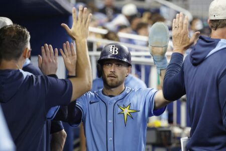 May 17, 2025; Miami, Florida, USA; Tampa Bay Rays second baseman Brandon Lowe (8) is greeted in the dugout by teammates after scoring against the Miami Marlins during the fifth inning at loanDepot Park.