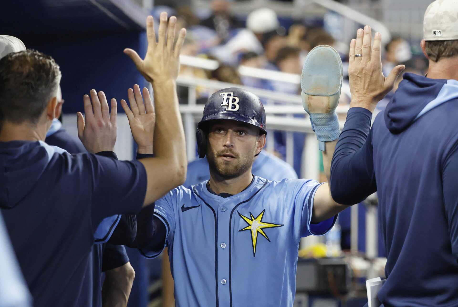 May 17, 2025; Miami, Florida, USA; Tampa Bay Rays second baseman Brandon Lowe (8) is greeted in the dugout by teammates after scoring against the Miami Marlins during the fifth inning at loanDepot Park.