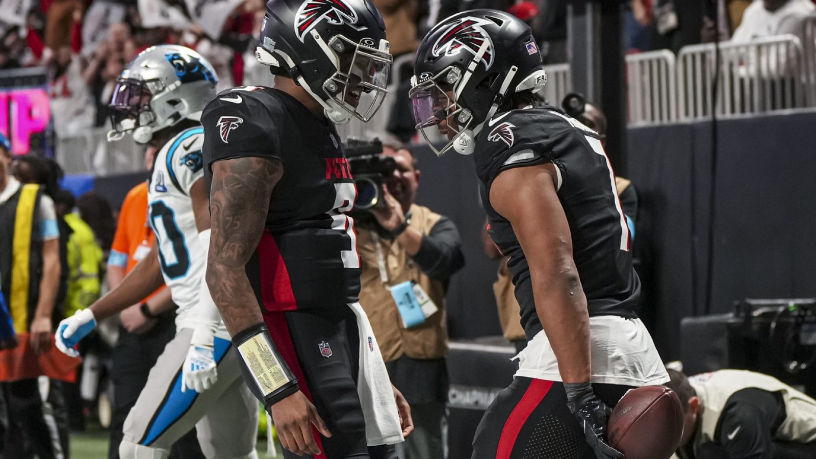 Jan 5, 2025; Atlanta, Georgia, USA; Atlanta Falcons running back Bijan Robinson (7) reacts with quarterback Michael Penix Jr. (9) after running for a touchdown against the Carolina Panthers during the second half at Mercedes-Benz Stadium.