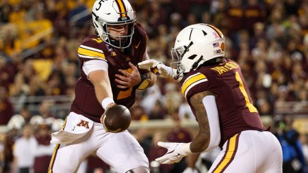 Oct 11, 2025; Minneapolis, Minnesota, USA; Minnesota Golden Gophers quarterback Drake Lindsey (5) hands the ball off to running back Darius Taylor (1) against the Purdue Boilermakers during the first half at Huntington Bank Stadium.