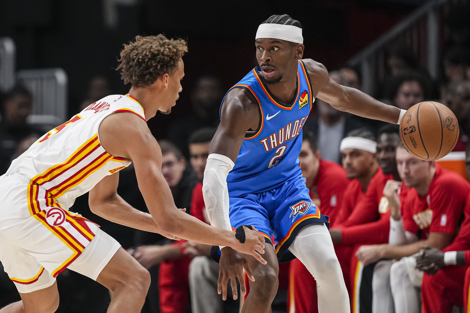 Oct 25, 2025; Atlanta, Georgia, USA; Oklahoma City Thunder guard Shai Gilgeous-Alexander (2) controls the ball against Atlanta Hawks guard Dyson Daniels (5) during the first half at State Farm Arena.