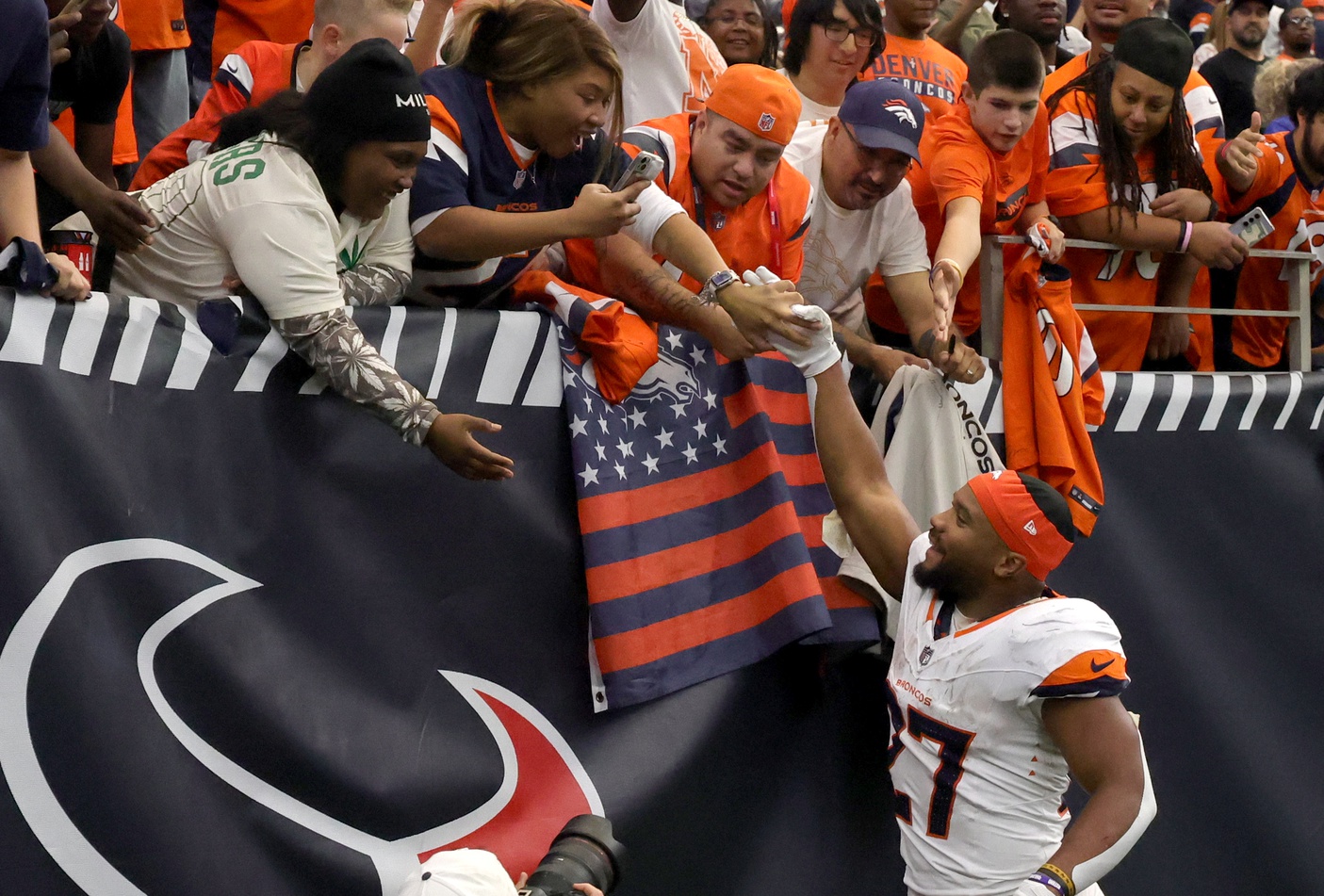 Denver Broncos running back J.K. Dobbins (27) celebrates with fans after defeating the Houston Texans at NRG Stadium.
