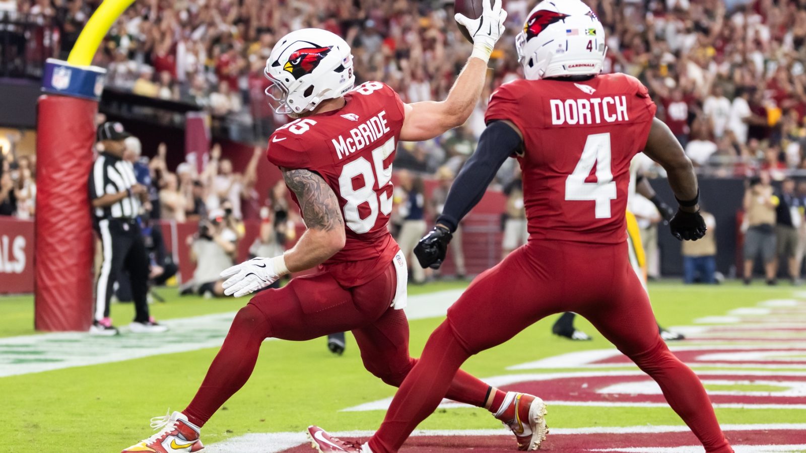 Oct 19, 2025; Glendale, Arizona, USA; Arizona Cardinals tight end Trey McBride (85) spikes the ball as he celebrates a touchdown with teammate Greg Dortch (4) against the Green Bay Packers in the second half at State Farm Stadium.