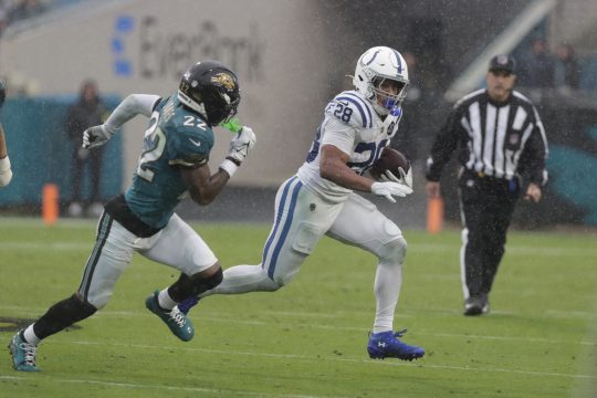 Dec 7, 2025; Jacksonville, Florida, USA; Indianapolis Colts running back Jonathan Taylor (28) carries the ball as Jacksonville Jaguars cornerback Jarrian Jones (22) during the first half at EverBank Stadium.
