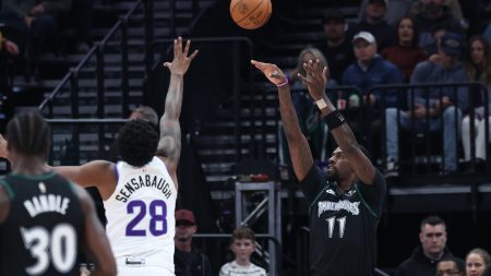 Nov 10, 2025; Salt Lake City, Utah, USA; Minnesota Timberwolves center Naz Reid (11) makes a three-point basket over Utah Jazz forward Brice Sensabaugh (28) during the first quarter at Delta Center.