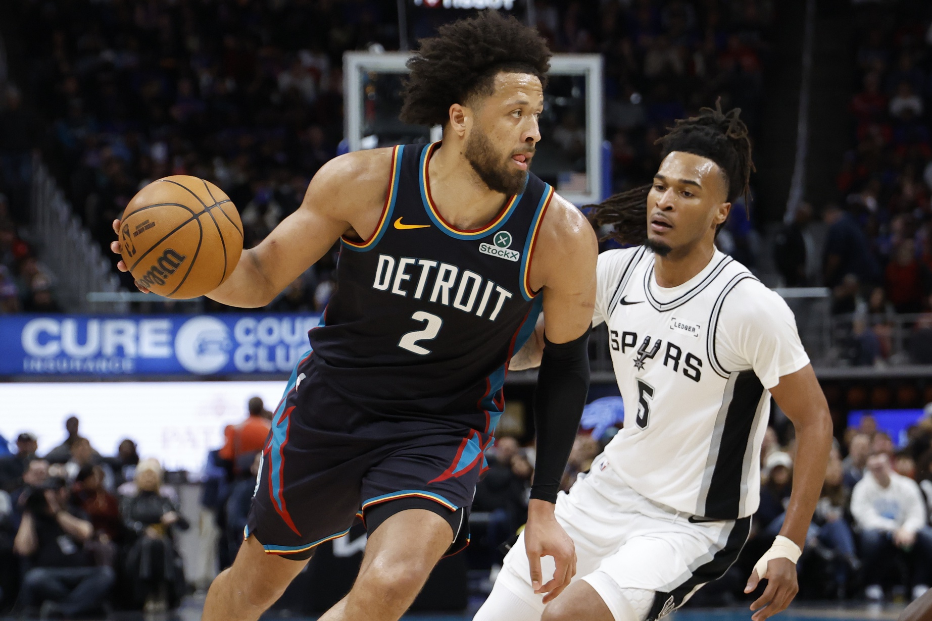 Feb 23, 2026; Detroit, Michigan, USA; Detroit Pistons guard Cade Cunningham (2) dribbles on San Antonio Spurs guard Stephon Castle (5) in the second half at Little Caesars Arena.