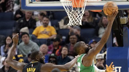 Feb 19, 2026; San Francisco, California, USA; Boston Celtics guard Jaylen Brown (7) lays the ball up ahead of Golden State Warriors forward Draymond Green (23) during the third quarter at Chase Center.