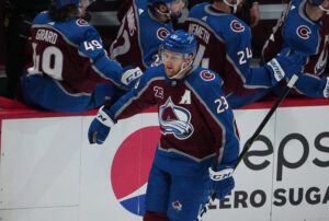 Colorado Avalanche center Nathan MacKinnon celebrates with teammates on the bench after he scored a goal