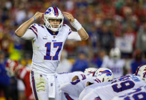 Buffalo Bills quarterback Josh Allen points both fingers to his helmet to signal to the offense before snapping the ball