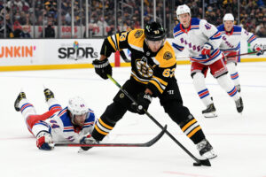 Boston Bruins center Brad Marchand maneuvering the puck against the New York Rangers