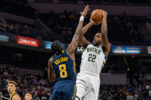 Milwaukee Bucks forward Khris Middleton shoots the ball while Indiana Pacers forward Justin Holiday defends