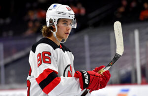 New Jersey Devils center Jack Hughes holds his hockey stick during a break in game action