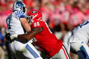 Georgia defensive lineman Jalen Carter wraps his arms around Kentucky Wildcats quarterback Will Levis and sacks him during a game