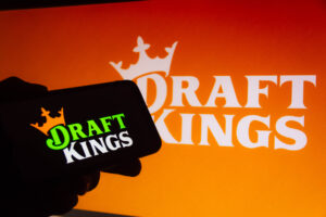 DraftKings logo banner in background with draftkings image on cellphone