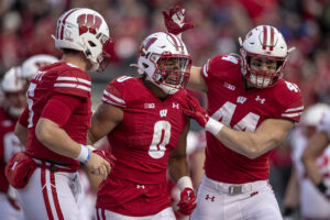 Wisconsin Badgers quarterback Graham Mertz (5) and Wisconsin Badgers fullback John Chenal (44) celebrate with Wisconsin Badgers running back Braelon Allen (0) after a long touchdown run durning a college football game between the Nebraska Cornhuskers and the Wisconsin Badgers on November 20th, 2021 at Camp Randall Stadium in Madison, WI.