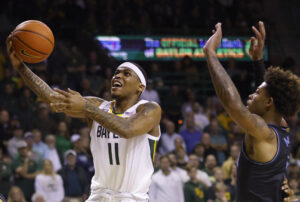 James Akinjo #11 of the Baylor Bears drives inside to score as Justin Moore #5 of the Villanova Wildcats defends in the second half at the Ferrell Center on December 12, 2021 in Waco, Texas. 