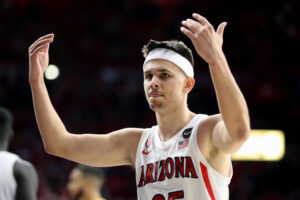 Arizona guard Kerr Kriisa encourages the crowd to make some noise during the second half of a Pac-12 basketball game between the USC Trojans