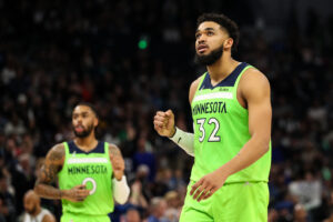 Karl-Anthony Towns #32 celebrates recording an assist on a basket made by D'Angelo Russell #0 of the Minnesota Timberwolves against the Milwaukee Bucks in the fourth quarter of the game at Target Center on March 19, 2022 in Minneapolis, Minnesota