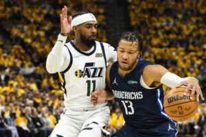 Jalen Brunson #13 of the Dallas Mavericks drives into Mike Conley #11 of the Utah Jazz during the first half of Game Four of the Western Conference First Round Playoffs at Vivint Smart Home Arena on April 23, 2022 in Salt Lake City, Utah.