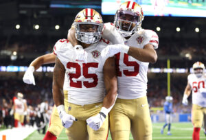 San Francisco 49ers running back Elijah Mitchell celebrates with a teammate after a touchdown