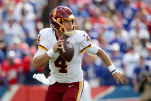 Washington Football Team quarterback #4 Taylor Heinicke scrambles out of the pocket against the Bills.