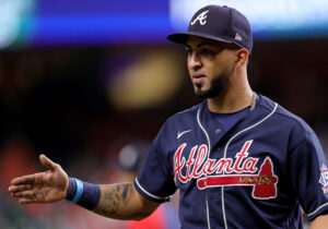 Atlanta Braves second baseman/outfielder Eddie Rosario extends his right hand to shake hands with an unpictured teammate following a playoff victory