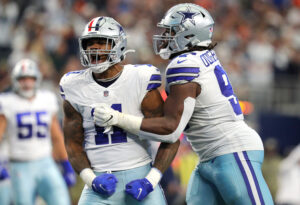 Micah Parsons #11 and Osa Odighizuwa #97 of the Dallas Cowboys celebrate after a sack of Teddy Bridgewater #5 of the Denver Broncos during the third quarter at AT&T Stadium on November 07, 2021 in Arlington, Texas.