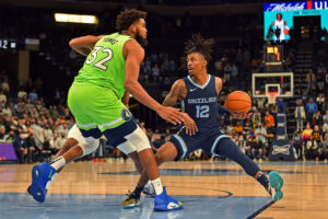 Ja Morant #12 of the Memphis Grizzlies handles the ball against Karl-Anthony Towns #32