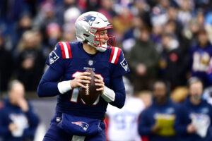 Mac Jones #10 of the New England Patriots looks to make a pass play against the Tennessee Titans in the first quarter at Gillette Stadium on November 28, 2021 in Foxborough, Massachusetts.